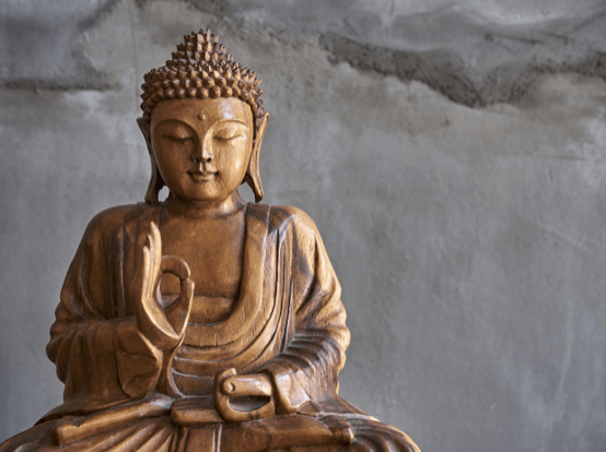 A carved wooden Buddha seated in serene meditation